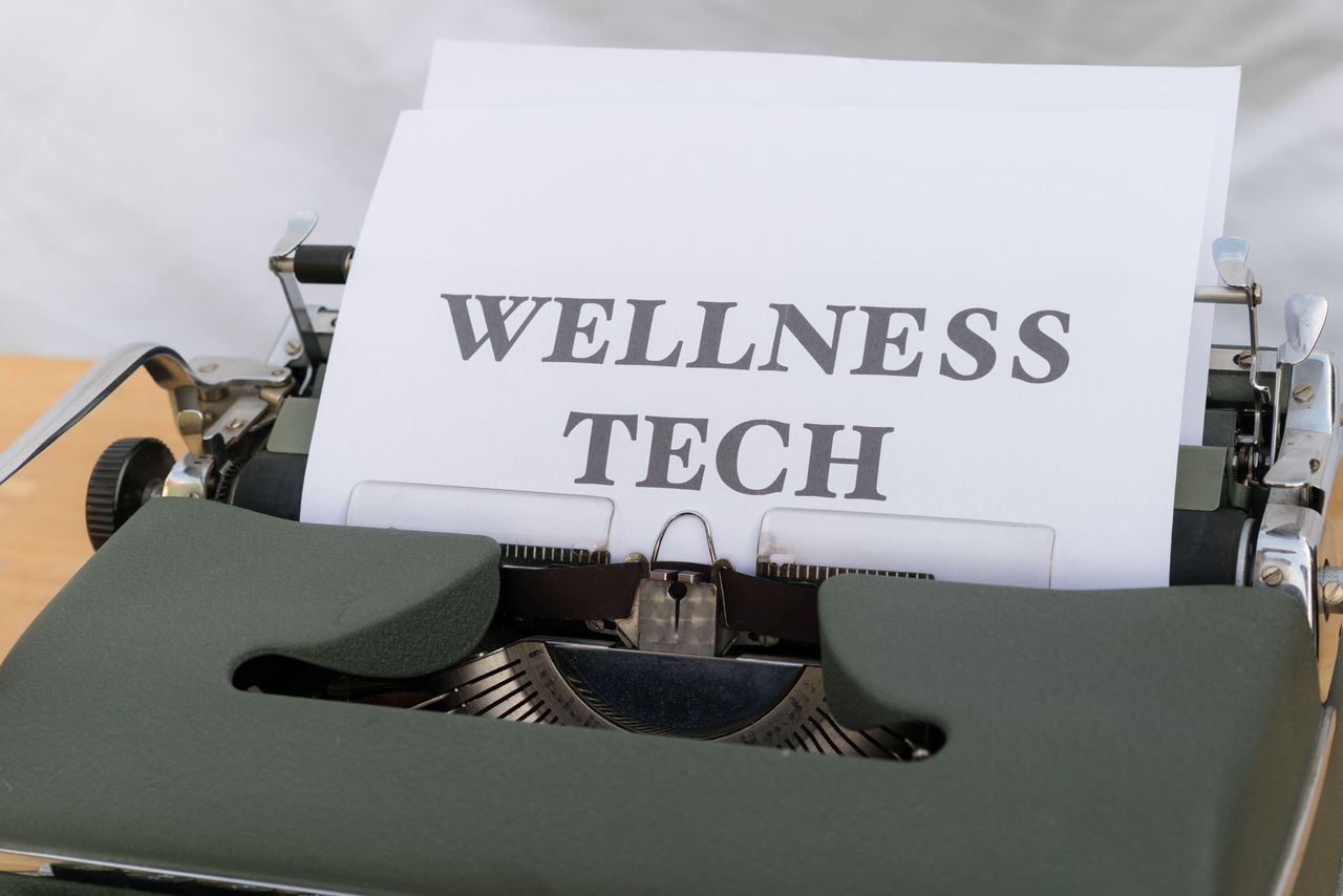 services-05 A close-up of a vintage typewriter featuring a paper with the words 'Wellness Tech.'